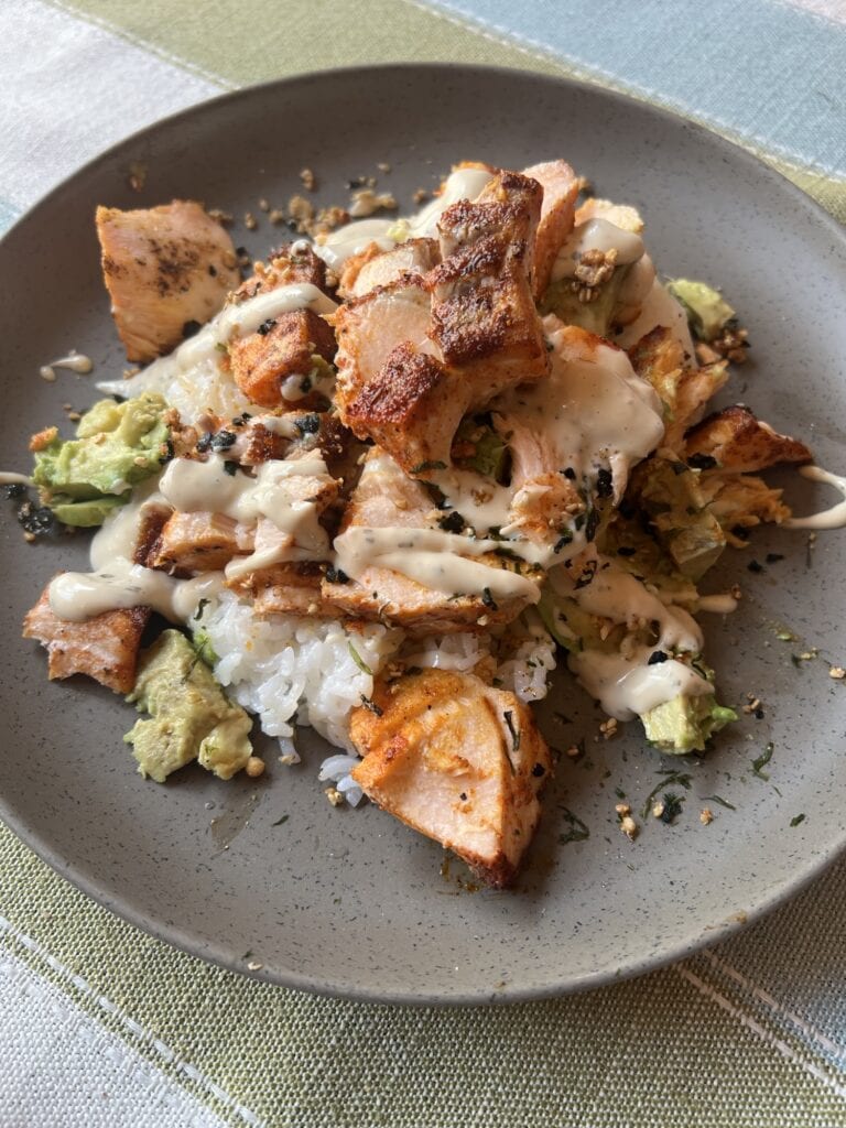 Delicious chicken and rice bowl with vegetables and creamy sauce.