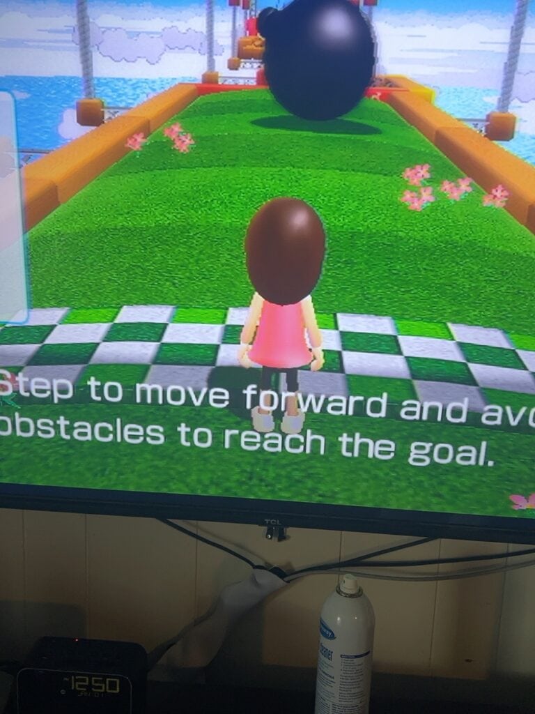 Virtual game character avoiding obstacles on a colorful pathway.