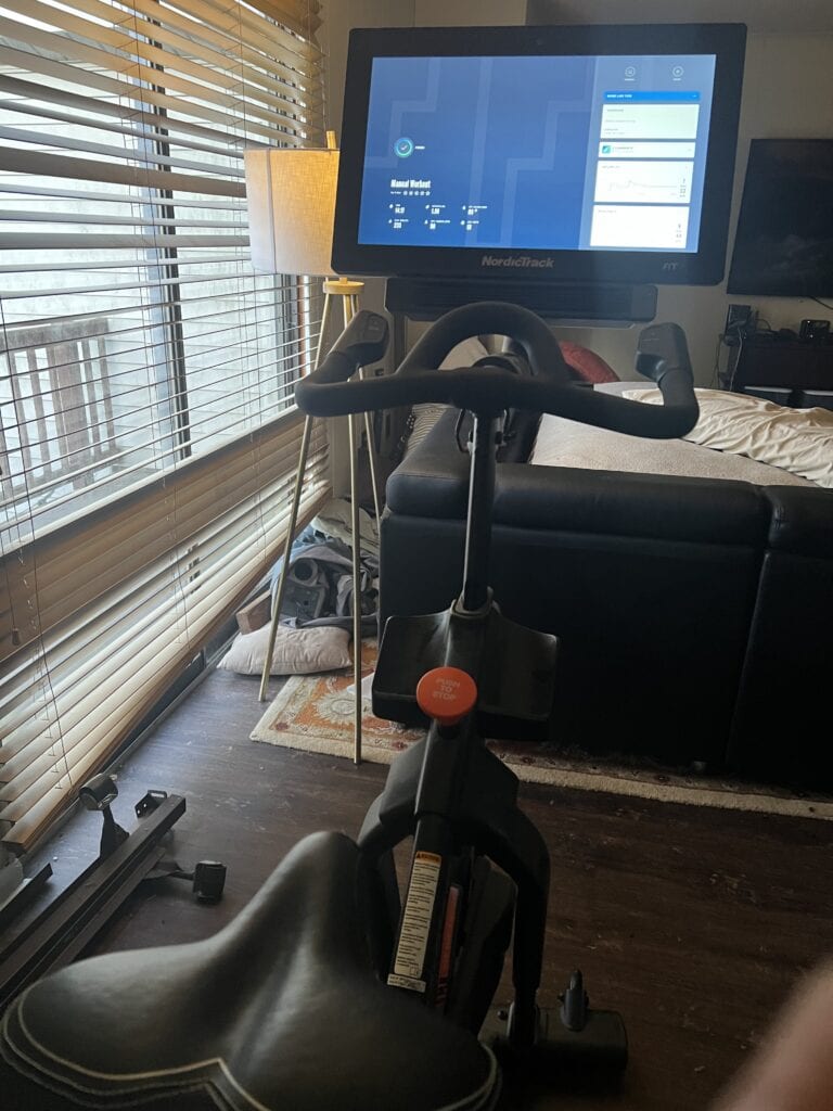 Modern exercise bike with digital display in living room setting.