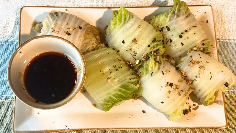Lettuce wraps with dipping sauce on a rectangular plate for healthy eating.