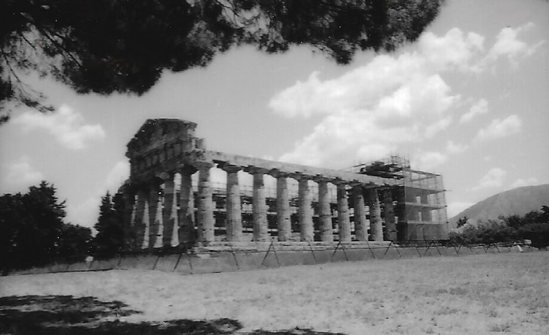 Ancient Greek temple under renovation with scaffolding and scaffolding around it.