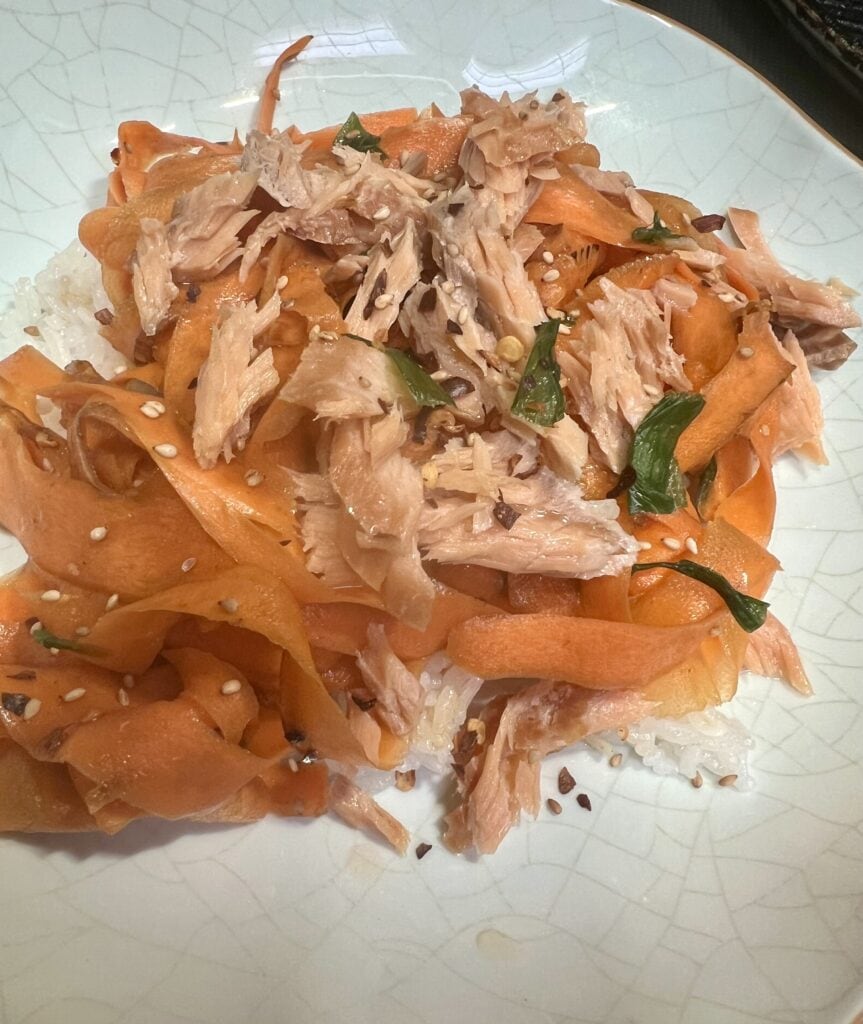 Tinned fish with vegetables on a plate, healthy lunch option.