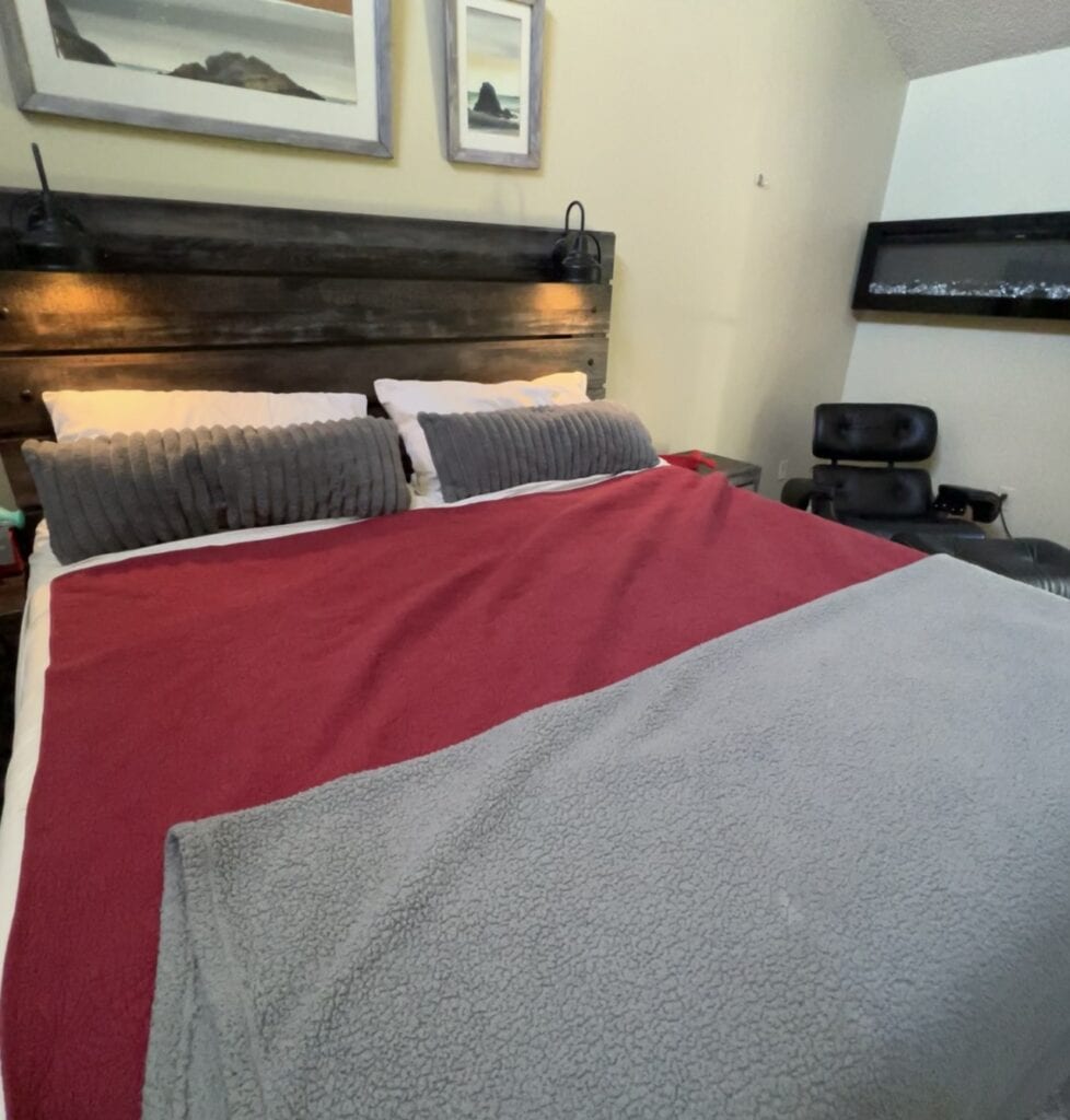 Modern bedroom with cozy bed, gray pillows, and minimalist decor.
