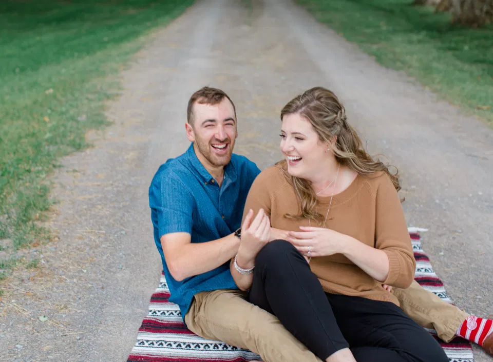 Laughing a lot! - Fun on the Farm - Farm Engagement Session - Blue and Brown Engagement Session Inspiration - Natural Engagement Session Posing - Ideas for what to wear for Engagement Photography, Modern Engagement Session Inspiration Wardrobe Ideas. Unsure of what to wear for your engagement photos, we've got you! Romantic brown with black leggings for Summer Engagement in Almonte. Grey Loft Studio is Ottawa's Wedding and Engagement Photographer for Real couples, showcasing photos that are modern, bright, and fun.