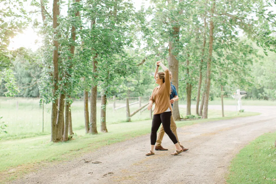Dancing- Natural Posing for Photo Session - Couples Photo Session Fun - Fun on the Farm - Farm Engagement Session - Blue and Brown Engagement Session Inspiration - Natural Engagement Session Posing - Ideas for what to wear for Engagement Photography, Modern Engagement Session Inspiration Wardrobe Ideas. Unsure of what to wear for your engagement photos, we've got you! Romantic brown with black leggings for Summer Engagement in Almonte. Grey Loft Studio is Ottawa's Wedding and Engagement Photographer for Real couples, showcasing photos that are modern, bright, and fun.