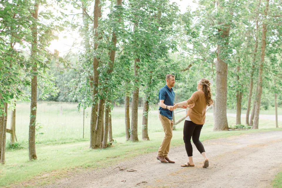 Natural Posing for Photo Session - Couples Photo Session Fun - Fun on the Farm - Farm Engagement Session - Blue and Brown Engagement Session Inspiration - Natural Engagement Session Posing - Ideas for what to wear for Engagement Photography, Modern Engagement Session Inspiration Wardrobe Ideas. Unsure of what to wear for your engagement photos, we've got you! Romantic brown with black leggings for Summer Engagement in Almonte. Grey Loft Studio is Ottawa's Wedding and Engagement Photographer for Real couples, showcasing photos that are modern, bright, and fun.
