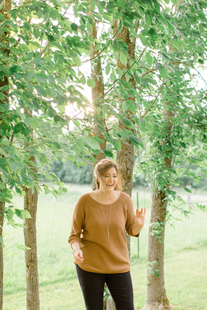 Laughing at the wind blowing hair everywhere - Natural Posing for Photo Session - Couples Photo Session Fun - Fun on the Farm - Farm Engagement Session - Blue and Brown Engagement Session Inspiration - Natural Engagement Session Posing - Ideas for what to wear for Engagement Photography, Modern Engagement Session Inspiration Wardrobe Ideas. Unsure of what to wear for your engagement photos, we've got you! Romantic brown with black leggings for Summer Engagement in Almonte. Grey Loft Studio is Ottawa's Wedding and Engagement Photographer for Real couples, showcasing photos that are modern, bright, and fun.