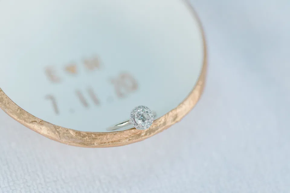 Ring shot in Custom Ring Dish -  Ideas for what to wear for Engagement Photography, Modern Engagement Session Inspiration Wardrobe Ideas. Unsure of what to wear for your engagement photos, we've got you! Romantic blue Romper and neutral Shirts and polo. Boat Shoes and Flip Flops. Engagement in Gananoque. Grey Loft Studio is Ottawa's Wedding and Engagement Photographer Videographer for Real couples, showcasing photos that are modern, bright, and fun.
