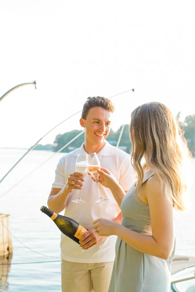 Pop the Champagne - Ideas for what to wear for Engagement Photography, Modern Engagement Session Inspiration Wardrobe Ideas. Unsure of what to wear for your engagement photos, we've got you! Romantic blue Romper and neutral Shirts and polo. Boat Shoes and Flip Flops. Engagement in Gananoque. Grey Loft Studio is Ottawa's Wedding and Engagement Photographer Videographer for Real couples, showcasing photos that are modern, bright, and fun.