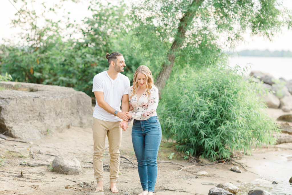 Walking on the Beach - Ideas for what to wear for Engagement Photography, Modern Engagement Session Inspiration Wardrobe Ideas. Unsure of what to wear for your engagement photos, we've got you! Romantic floral shirt & jeans.  White T-shirt & neutral pants . Boat Shoes and Fancy. beaded sandals. Engagement at Petrie Island, Orleans. Grey Loft Studio is Ottawa's Wedding and Engagement Photographer Videographer for Real couples, showcasing photos that are modern, bright, and fun.