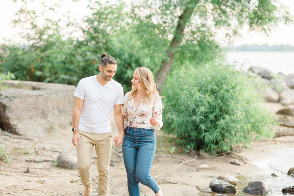 Walking on the Beach - Ideas for what to wear for Engagement Photography, Modern Engagement Session Inspiration Wardrobe Ideas. Unsure of what to wear for your engagement photos, we've got you! Romantic floral shirt & jeans.  White T-shirt & neutral pants . Boat Shoes and Fancy. beaded sandals. Engagement at Petrie Island, Orleans. Grey Loft Studio is Ottawa's Wedding and Engagement Photographer Videographer for Real couples, showcasing photos that are modern, bright, and fun.