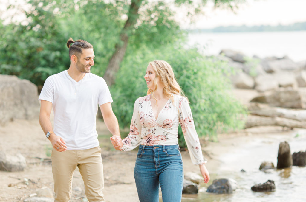 Walking on the Beach - Ideas for what to wear for Engagement Photography, Modern Engagement Session Inspiration Wardrobe Ideas. Unsure of what to wear for your engagement photos, we've got you! Romantic floral shirt & jeans.  White T-shirt & neutral pants . Boat Shoes and Fancy. beaded sandals. Engagement at Petrie Island, Orleans. Grey Loft Studio is Ottawa's Wedding and Engagement Photographer Videographer for Real couples, showcasing photos that are modern, bright, and fun.
