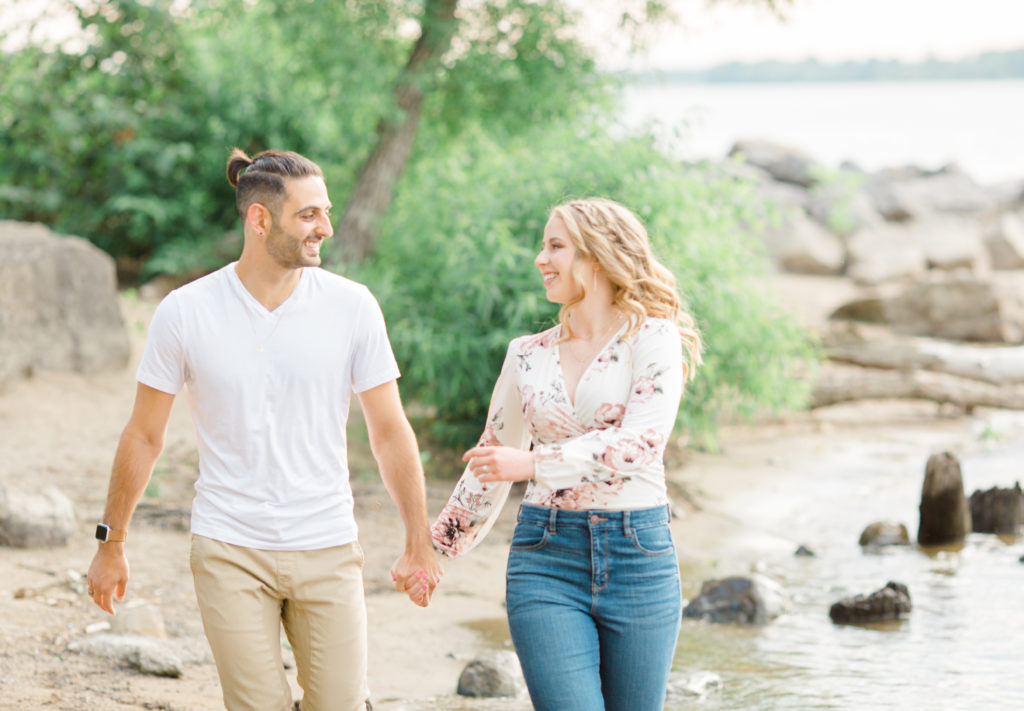 Frolic - Walking on the Beach - Ideas for what to wear for Engagement Photography, Modern Engagement Session Inspiration Wardrobe Ideas. Unsure of what to wear for your engagement photos, we've got you! Romantic floral shirt & jeans.  White T-shirt & neutral pants . Boat Shoes and Fancy. beaded sandals. Engagement at Petrie Island, Orleans. Grey Loft Studio is Ottawa's Wedding and Engagement Photographer Videographer for Real couples, showcasing photos that are modern, bright, and fun.