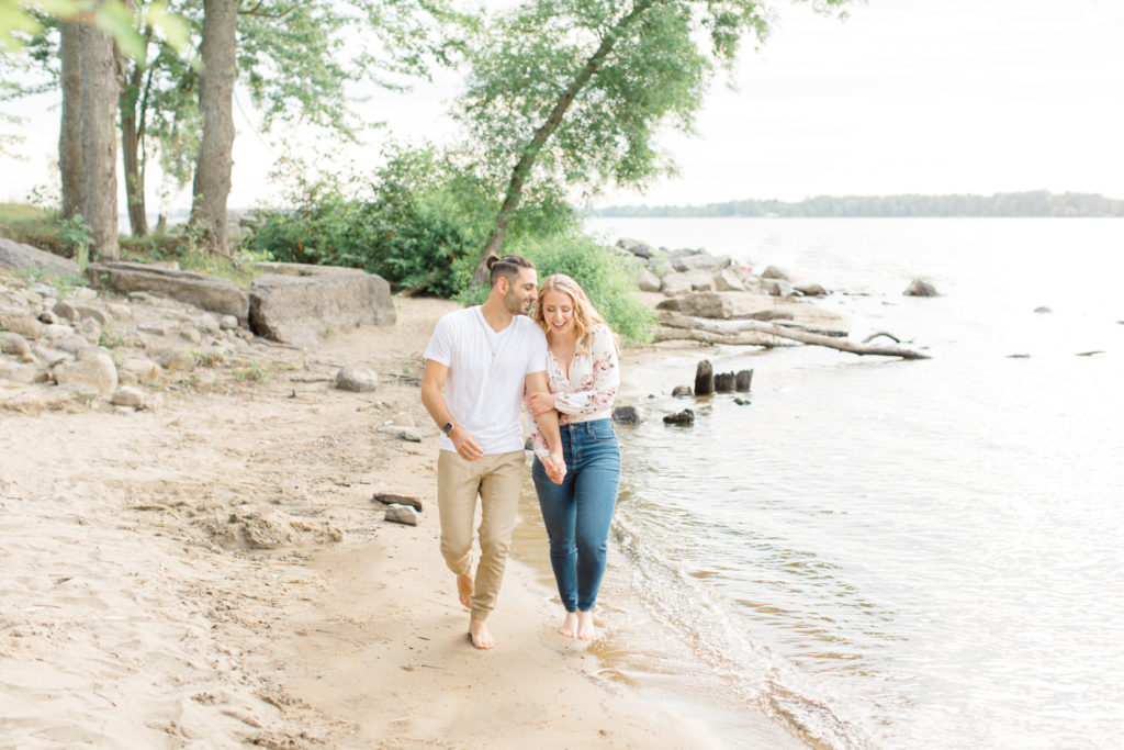 Walking on the Beach - Ideas for what to wear for Engagement Photography, Modern Engagement Session Inspiration Wardrobe Ideas. Unsure of what to wear for your engagement photos, we've got you! Romantic floral shirt & jeans.  White T-shirt & neutral pants . Boat Shoes and Fancy. beaded sandals. Engagement at Petrie Island, Orleans. Grey Loft Studio is Ottawa's Wedding and Engagement Photographer Videographer for Real couples, showcasing photos that are modern, bright, and fun.