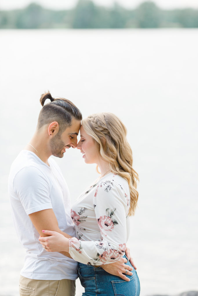 Forehead to Forehead- Ideas for what to wear for Engagement Photography, Modern Engagement Session Inspiration Wardrobe Ideas. Unsure of what to wear for your engagement photos, we've got you! Romantic floral shirt & jeans.  White T-shirt & neutral pants . Boat Shoes and Fancy. beaded sandals. Engagement at Petrie Island, Orleans. Grey Loft Studio is Ottawa's Wedding and Engagement Photographer Videographer for Real couples, showcasing photos that are modern, bright, and fun.