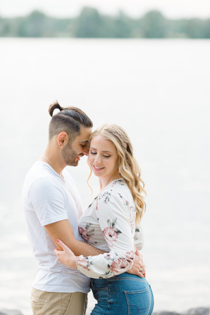 Cute Poses on the beach - Ideas for what to wear for Engagement Photography, Modern Engagement Session Inspiration Wardrobe Ideas. Unsure of what to wear for your engagement photos, we've got you! Romantic floral shirt & jeans.  White T-shirt & neutral pants . Boat Shoes and Fancy. beaded sandals. Engagement at Petrie Island, Orleans. Grey Loft Studio is Ottawa's Wedding and Engagement Photographer Videographer for Real couples, showcasing photos that are modern, bright, and fun.