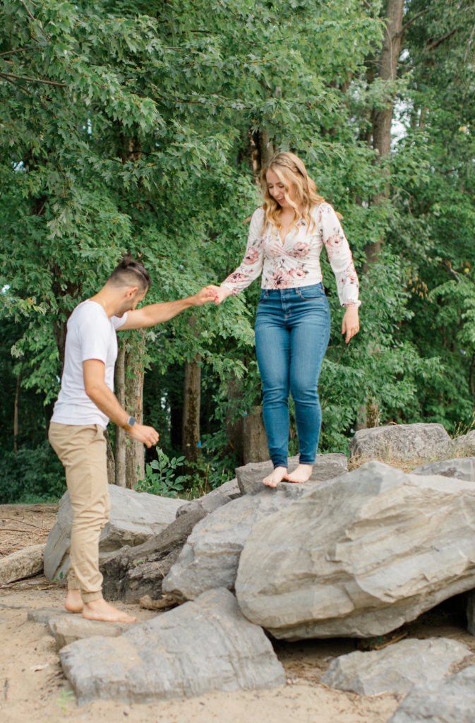 Cute Poses on the beach - Ideas for what to wear for Engagement Photography, Modern Engagement Session Inspiration Wardrobe Ideas. Unsure of what to wear for your engagement photos, we've got you! Romantic floral shirt & jeans.  White T-shirt & neutral pants . Boat Shoes and Fancy. beaded sandals. Engagement at Petrie Island, Orleans. Grey Loft Studio is Ottawa's Wedding and Engagement Photographer Videographer for Real couples, showcasing photos that are modern, bright, and fun.