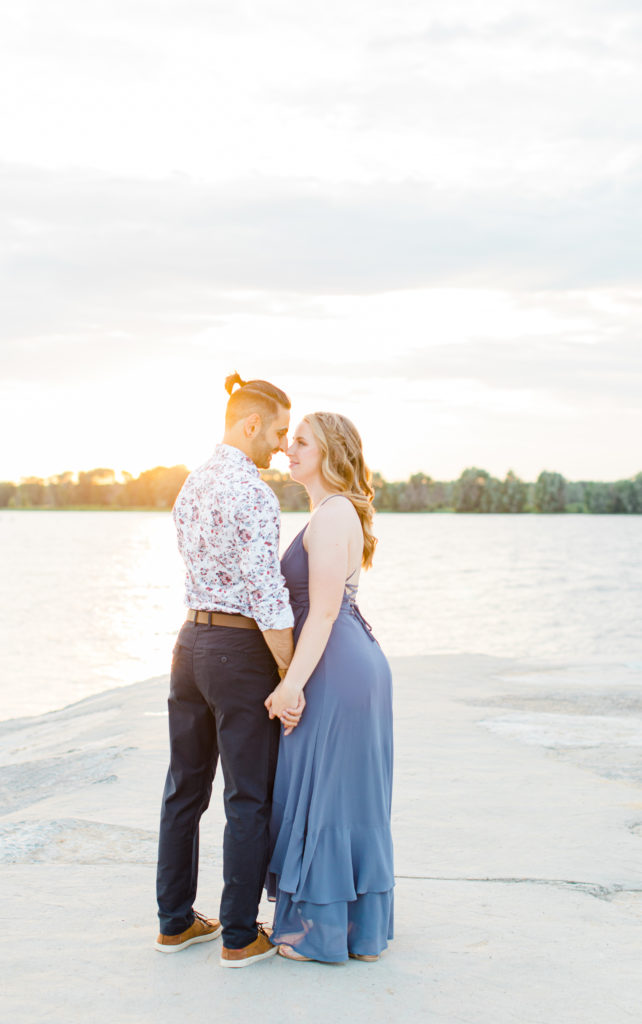 Cute Poses on the beach - Ideas for what to wear for Engagement Photography, Modern Engagement Session Inspiration Wardrobe Ideas. Unsure of what to wear for your engagement photos, we've got you! Romantic floral shirt & jeans.  White T-shirt & neutral pants . Boat Shoes and Fancy. beaded sandals. Engagement at Petrie Island, Orleans. Grey Loft Studio is Ottawa's Wedding and Engagement Photographer Videographer for Real couples, showcasing photos that are modern, bright, and fun.