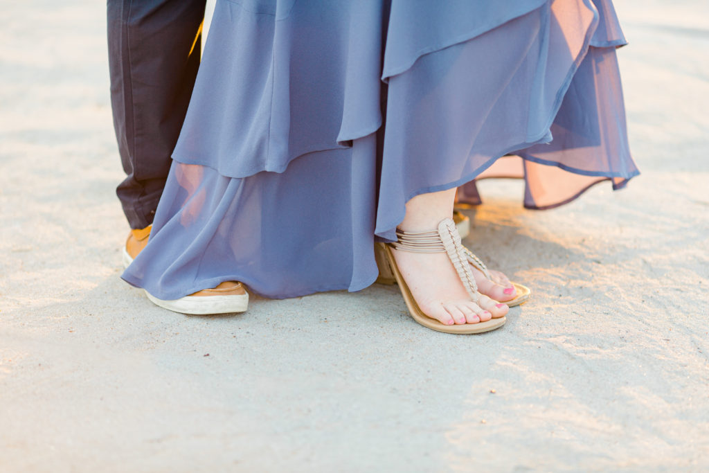 Cute Poses on the beach - Ideas for what to wear for Engagement Photography, Modern Engagement Session Inspiration Wardrobe Ideas. Unsure of what to wear for your engagement photos, we've got you! Romantic floral shirt & jeans.  White T-shirt & neutral pants . Boat Shoes and Fancy. beaded sandals. Engagement at Petrie Island, Orleans. Grey Loft Studio is Ottawa's Wedding and Engagement Photographer Videographer for Real couples, showcasing photos that are modern, bright, and fun.