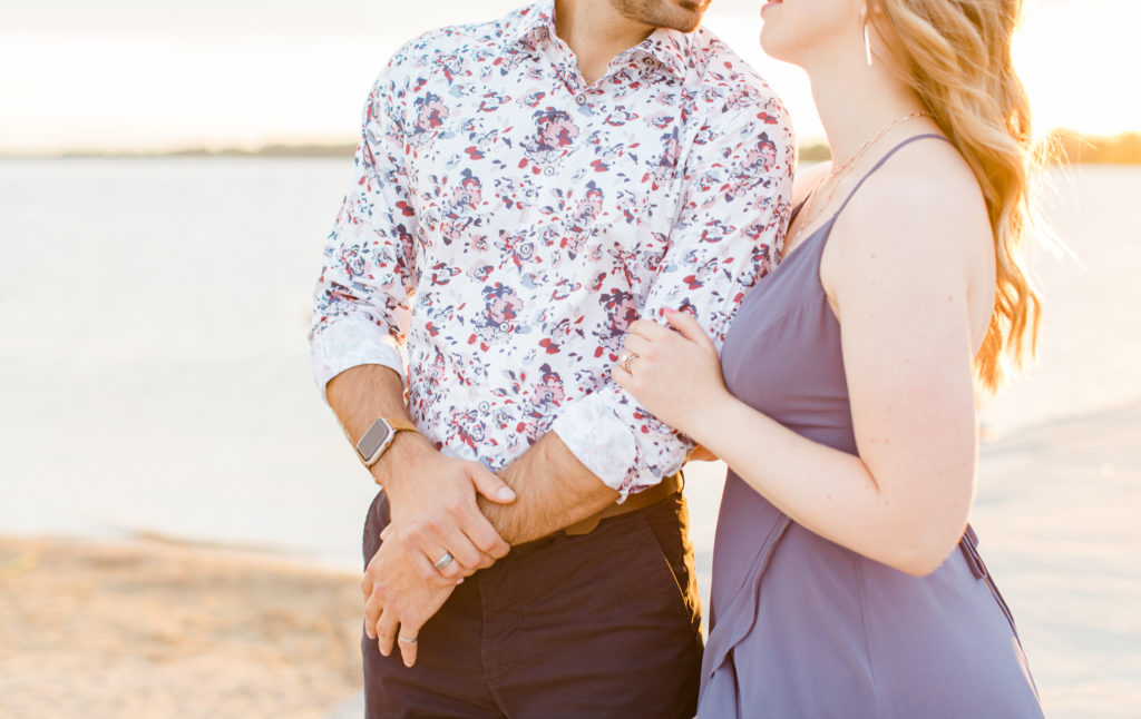 Cute Poses on the beach - Ideas for what to wear for Engagement Photography, Modern Engagement Session Inspiration Wardrobe Ideas. Unsure of what to wear for your engagement photos, we've got you! Romantic floral shirt & jeans.  White T-shirt & neutral pants . Boat Shoes and Fancy. beaded sandals. Engagement at Petrie Island, Orleans. Grey Loft Studio is Ottawa's Wedding and Engagement Photographer Videographer for Real couples, showcasing photos that are modern, bright, and fun.