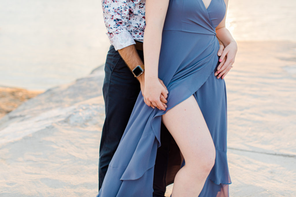 Cute Poses on the beach - Ideas for what to wear for Engagement Photography, Modern Engagement Session Inspiration Wardrobe Ideas. Unsure of what to wear for your engagement photos, we've got you! Romantic floral shirt & jeans.  White T-shirt & neutral pants . Boat Shoes and Fancy. beaded sandals. Engagement at Petrie Island, Orleans. Grey Loft Studio is Ottawa's Wedding and Engagement Photographer Videographer for Real couples, showcasing photos that are modern, bright, and fun.