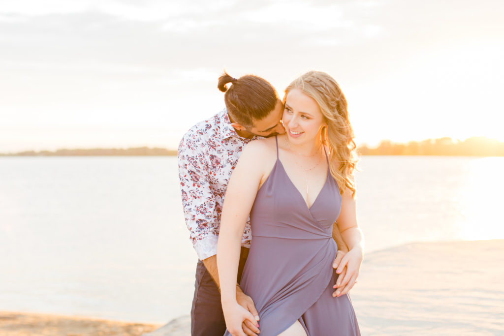 Cute Poses on the beach - Ideas for what to wear for Engagement Photography, Modern Engagement Session Inspiration Wardrobe Ideas. Unsure of what to wear for your engagement photos, we've got you! Romantic floral shirt & jeans.  White T-shirt & neutral pants . Boat Shoes and Fancy. beaded sandals. Engagement at Petrie Island, Orleans. Grey Loft Studio is Ottawa's Wedding and Engagement Photographer Videographer for Real couples, showcasing photos that are modern, bright, and fun.