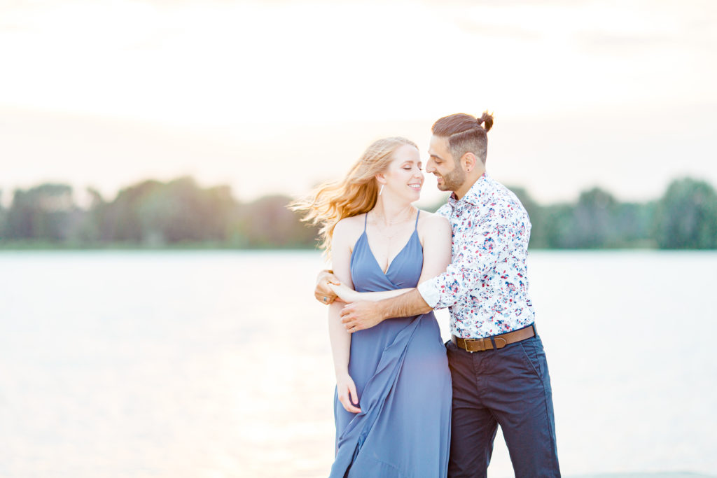 Cute Poses on the beach - Ideas for what to wear for Engagement Photography, Modern Engagement Session Inspiration Wardrobe Ideas. Unsure of what to wear for your engagement photos, we've got you! Romantic floral shirt & jeans.  White T-shirt & neutral pants . Boat Shoes and Fancy. beaded sandals. Engagement at Petrie Island, Orleans. Grey Loft Studio is Ottawa's Wedding and Engagement Photographer Videographer for Real couples, showcasing photos that are modern, bright, and fun.