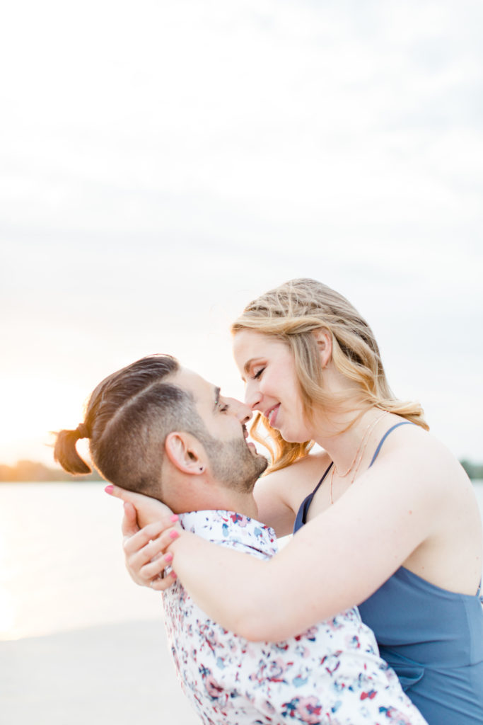 Cute Poses on the beach - Ideas for what to wear for Engagement Photography, Modern Engagement Session Inspiration Wardrobe Ideas. Unsure of what to wear for your engagement photos, we've got you! Romantic floral shirt & jeans.  White T-shirt & neutral pants . Boat Shoes and Fancy. beaded sandals. Engagement at Petrie Island, Orleans. Grey Loft Studio is Ottawa's Wedding and Engagement Photographer Videographer for Real couples, showcasing photos that are modern, bright, and fun.