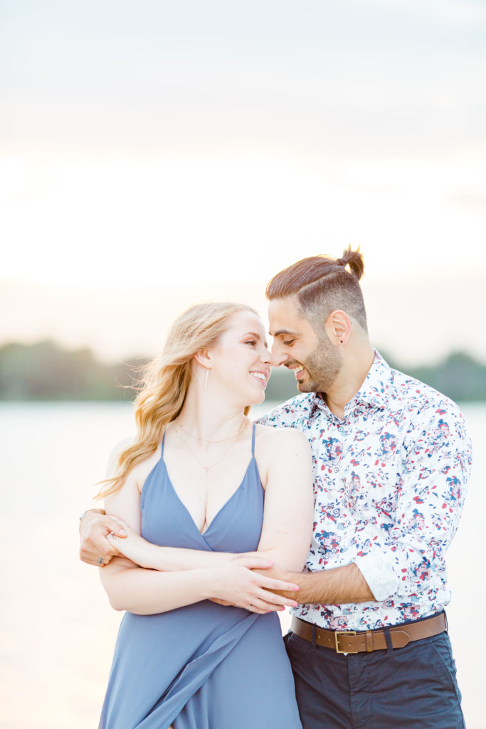 Cute Poses on the beach - Ideas for what to wear for Engagement Photography, Modern Engagement Session Inspiration Wardrobe Ideas. Unsure of what to wear for your engagement photos, we've got you! Romantic floral shirt & jeans.  White T-shirt & neutral pants . Boat Shoes and Fancy. beaded sandals. Engagement at Petrie Island, Orleans. Grey Loft Studio is Ottawa's Wedding and Engagement Photographer Videographer for Real couples, showcasing photos that are modern, bright, and fun.
