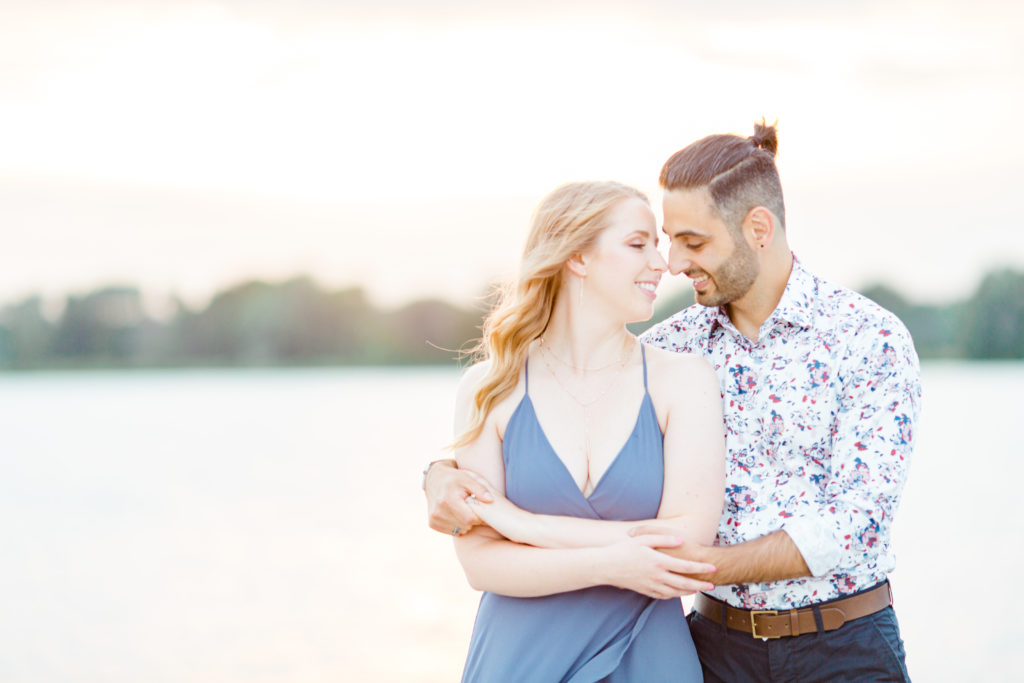 Cute Poses on the beach - Ideas for what to wear for Engagement Photography, Modern Engagement Session Inspiration Wardrobe Ideas. Unsure of what to wear for your engagement photos, we've got you! Romantic floral shirt & jeans.  White T-shirt & neutral pants . Boat Shoes and Fancy. beaded sandals. Engagement at Petrie Island, Orleans. Grey Loft Studio is Ottawa's Wedding and Engagement Photographer Videographer for Real couples, showcasing photos that are modern, bright, and fun.