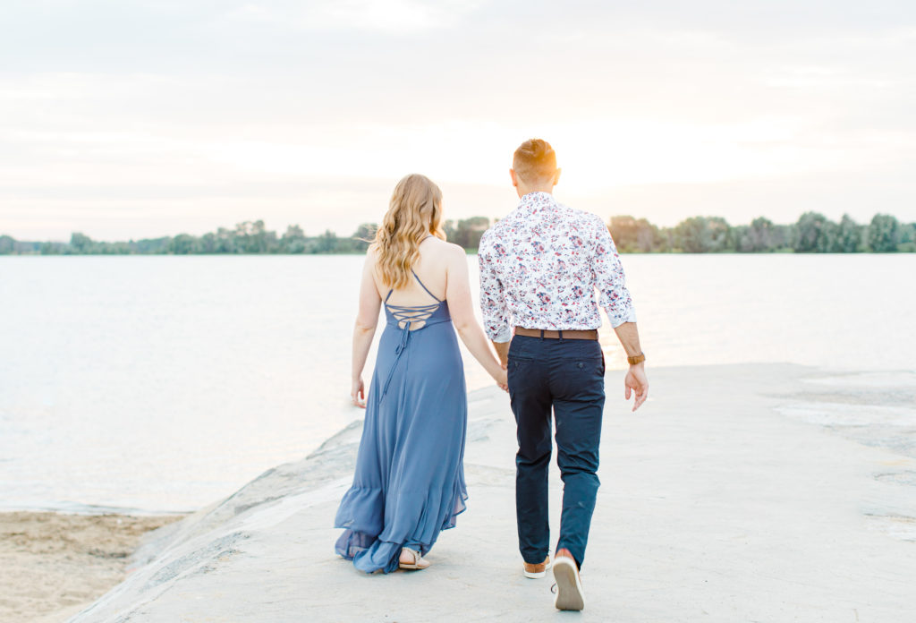 Cute Poses on the beach - Ideas for what to wear for Engagement Photography, Modern Engagement Session Inspiration Wardrobe Ideas. Unsure of what to wear for your engagement photos, we've got you! Romantic floral shirt & jeans.  White T-shirt & neutral pants . Boat Shoes and Fancy. beaded sandals. Engagement at Petrie Island, Orleans. Grey Loft Studio is Ottawa's Wedding and Engagement Photographer Videographer for Real couples, showcasing photos that are modern, bright, and fun.