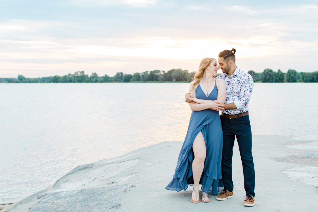 Cute Poses on the beach - Ideas for what to wear for Engagement Photography, Modern Engagement Session Inspiration Wardrobe Ideas. Unsure of what to wear for your engagement photos, we've got you! Romantic floral shirt & jeans.  White T-shirt & neutral pants . Boat Shoes and Fancy. beaded sandals. Engagement at Petrie Island, Orleans. Grey Loft Studio is Ottawa's Wedding and Engagement Photographer Videographer for Real couples, showcasing photos that are modern, bright, and fun.