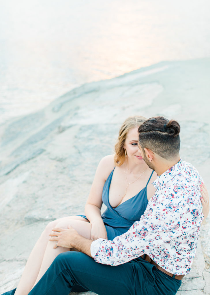 Cute Poses on the beach - Ideas for what to wear for Engagement Photography, Modern Engagement Session Inspiration Wardrobe Ideas. Unsure of what to wear for your engagement photos, we've got you! Romantic floral shirt & jeans.  White T-shirt & neutral pants . Boat Shoes and Fancy. beaded sandals. Engagement at Petrie Island, Orleans. Grey Loft Studio is Ottawa's Wedding and Engagement Photographer Videographer for Real couples, showcasing photos that are modern, bright, and fun.
