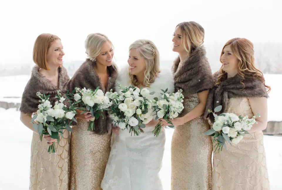 Winter Wedding - Bride with Bridesmaids - Gold, White, Greenery with Brown Furs - NYE Wedding - Natural Wedding Posing - Ideas for what to wear for Wedding on NYE Photography, Modern Wedding NYE Wardrobe inspiration- Unsure of what to wear for your wedding, we've got you! Romantic white with greenery theme. Lace Wedding Dress in Ottawa. Grey Loft Studio is Ottawa's Wedding and Engagement Photographer & Videographer for Real couples, showcasing photos that are modern, bright, and fun. Brookstreet Hotel Kanata