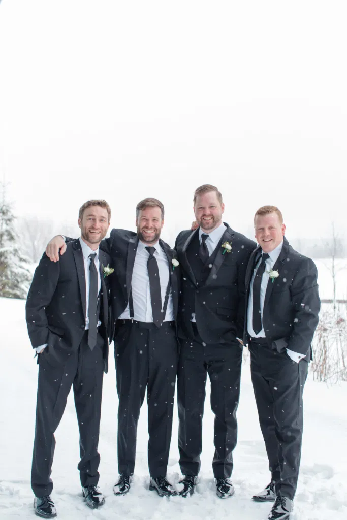 Snowy Groomsmen Photos - Winter Photos at Wedding - NYE Wedding - Natural Wedding Posing - Ideas for what to wear for Wedding on NYE Photography, Modern Wedding NYE Wardrobe inspiration- Must Have photo at Midnight - Unsure of what to wear for your wedding, we've got you! Romantic white with greenery theme. Lace Wedding Dress in Ottawa. Grey Loft Studio is Ottawa's Wedding and Engagement Photographer for Real couples, showcasing photos that are modern, bright, and fun.