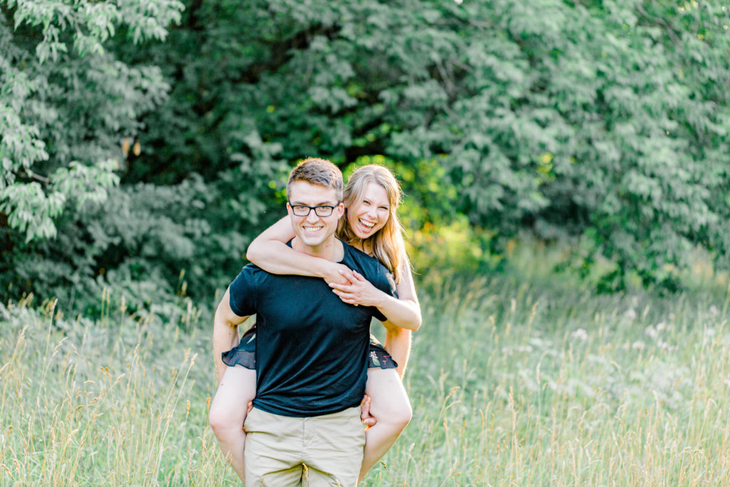 Piggy Back Pose -Cute Posing for Tall guys with short girls - Engagement Photo Poses- Posing close to Rideau Hall - Ideas for what to wear for Engagement Photography, Modern Engagement Session Inspiration Wardrobe Ideas. Unsure of what to wear for your engagement photos, we've got you! Romantic floral dress. Black Polo T-shirt & neutral pants . Boat Shoes and Fancy beaded wedges. Engagement downtown Ottawa. Grey Loft Studio is Ottawa's Wedding and Engagement Photographer Videographer for Real couples, showcasing photos that are modern, bright, and fun.