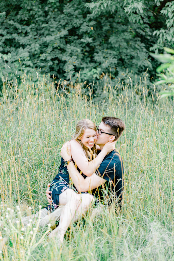 Sitting in Field -Cute Posing for Tall guys with short girls - Engagement Photo Poses- Posing close to Rideau Hall - Ideas for what to wear for Engagement Photography, Modern Engagement Session Inspiration Wardrobe Ideas. Unsure of what to wear for your engagement photos, we've got you! Romantic floral dress. Black Polo T-shirt & neutral pants . Boat Shoes and Fancy beaded wedges. Engagement downtown Ottawa. Grey Loft Studio is Ottawa's Wedding and Engagement Photographer Videographer for Real couples, showcasing photos that are modern, bright, and fun. Photographe Gatineau