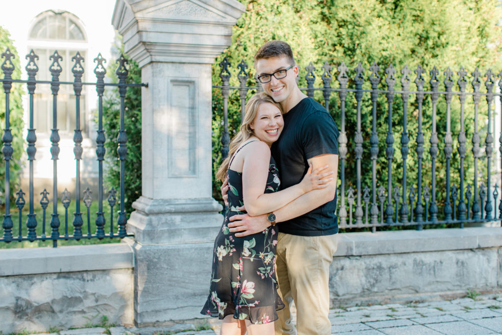 Laughing while posing at Rideau Hall - Ideas for what to wear for Engagement Photography, Modern Engagement Session Inspiration Wardrobe Ideas. Unsure of what to wear for your engagement photos, we've got you! Romantic floral dress. Black Polo T-shirt & neutral pants . Boat Shoes and Fancy beaded wedges. Engagement downtown Ottawa. Grey Loft Studio is Ottawa's Wedding and Engagement Photographer Videographer for Real couples, showcasing photos that are modern, bright, and fun.