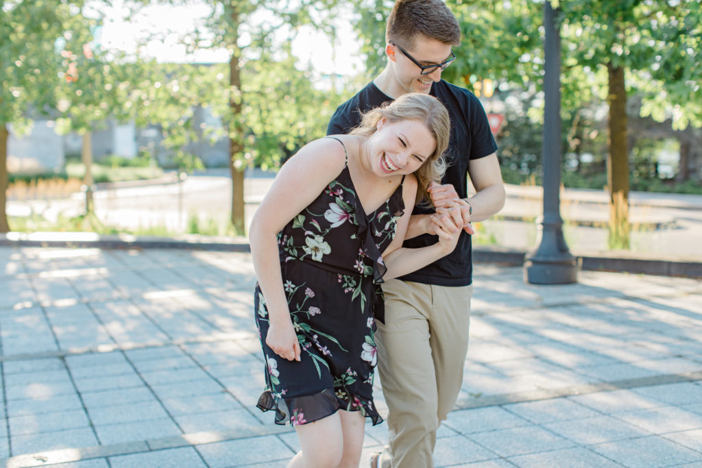 Cute couple Posing at Rideau Hall - Ideas for what to wear for Engagement Photography, Modern Engagement Session Inspiration Wardrobe Ideas. Unsure of what to wear for your engagement photos, we've got you! Romantic floral dress. Black Polo T-shirt & neutral pants . Boat Shoes and Fancy beaded wedges. Engagement downtown Ottawa. Grey Loft Studio is Ottawa's Wedding and Engagement Photographer Videographer for Real couples, showcasing photos that are modern, bright, and fun.