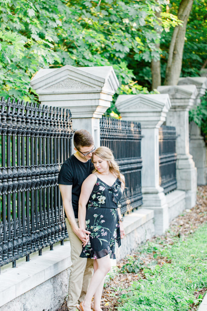 Holding Hands Shot - Engagement Photo Poses- Posing while at Rideau Hall - Ideas for what to wear for Engagement Photography, Modern Engagement Session Inspiration Wardrobe Ideas. Unsure of what to wear for your engagement photos, we've got you! Romantic floral dress. Black Polo T-shirt & neutral pants . Boat Shoes and Fancy beaded wedges. Engagement downtown Ottawa. Grey Loft Studio is Ottawa's Wedding and Engagement Photographer Videographer for Real couples, showcasing photos that are modern, bright, and fun.