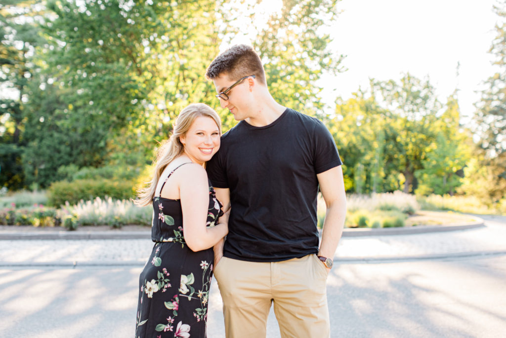Cute Posing for Tall guys with short girls - Holding Hands Shot - Engagement Photo Poses- Posing while at Rideau Hall - Ideas for what to wear for Engagement Photography, Modern Engagement Session Inspiration Wardrobe Ideas. Unsure of what to wear for your engagement photos, we've got you! Romantic floral dress. Black Polo T-shirt & neutral pants . Boat Shoes and Fancy beaded wedges. Engagement downtown Ottawa. Grey Loft Studio is Ottawa's Wedding and Engagement Photographer Videographer for Real couples, showcasing photos that are modern, bright, and fun.