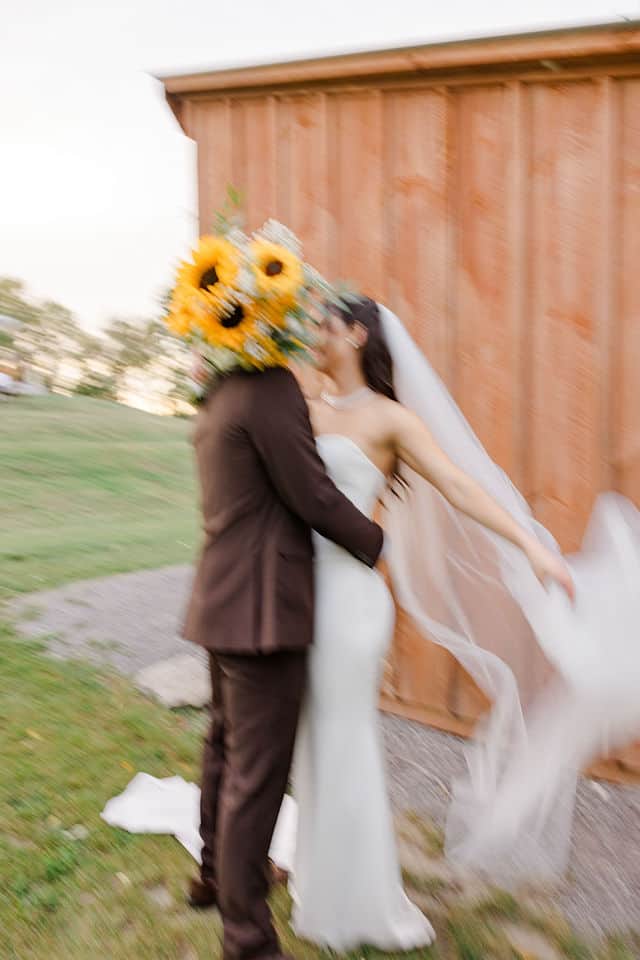 Bride holding a bouquet of homegrown sunflowers at an Ottawa farm wedding