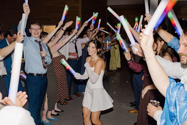 Guests forming a glowing human bridge for the bride's wedding-day outfit reveal