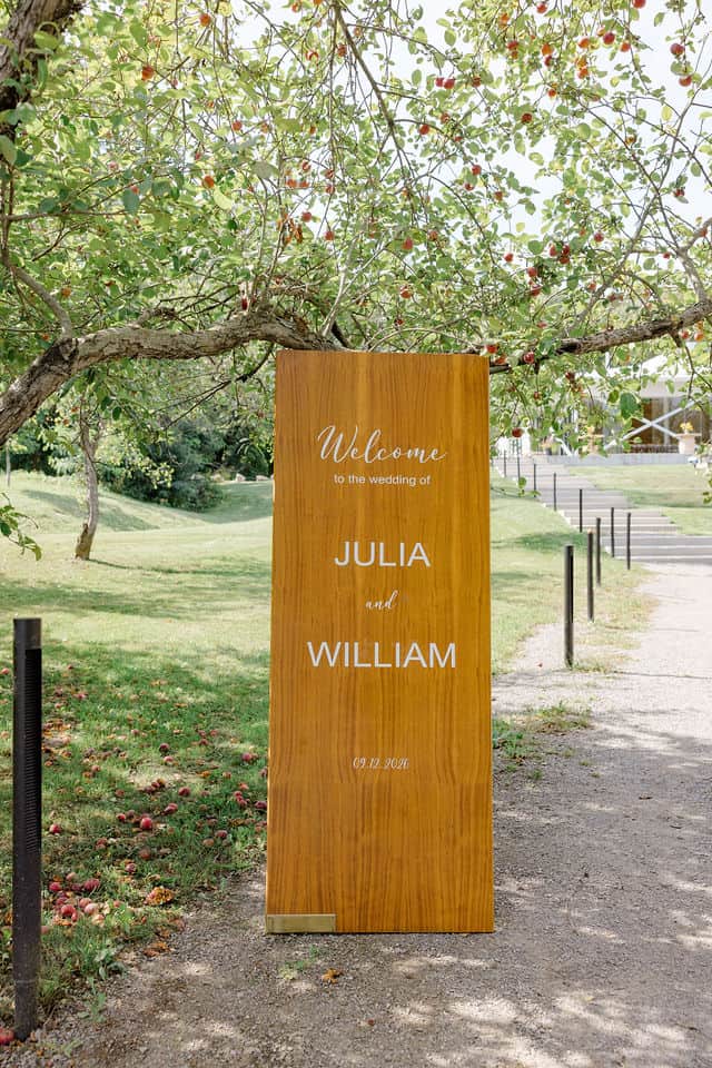 Custom wooden welcome sign designed by the bride at Julia Dickson Designs, in the orchard