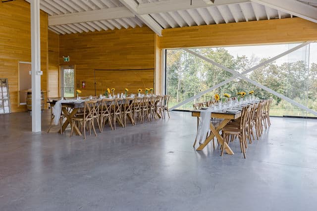 Reception tables set with sunflower centrepieces inside the cidery