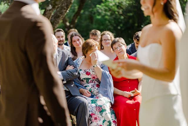 Bride tearing up during her wedding vows in the orchard