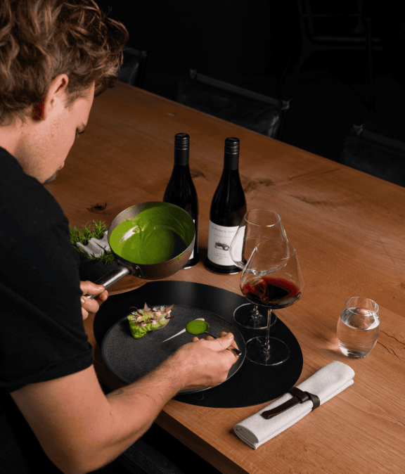 Elegant wine tasting setup with two bottles, a glass of red wine, and a water glass photographed by Whitsundays commercial photographer