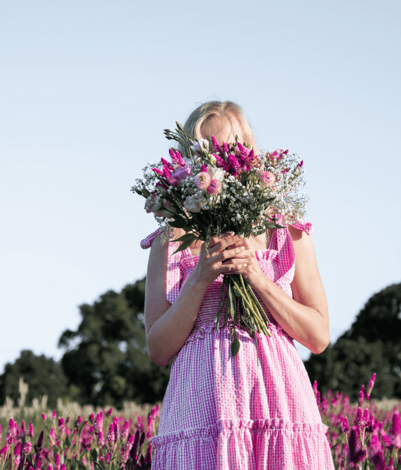 Beautiful woman holding a colorful flower bouquet outdoors.