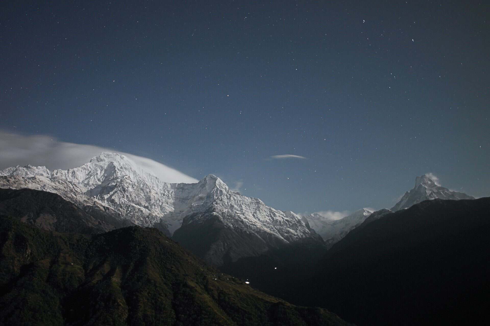 Night sky over snow-capped mountains in Fiordland National Park, New Zealand.