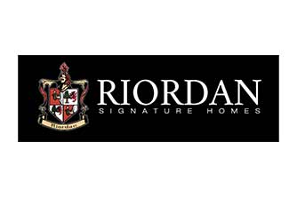 Logo for Riordan Signature Homes on a black background, featuring a detailed family crest with a shield and red, black, and white elements on the left, and the company name in white capital letters on the right.